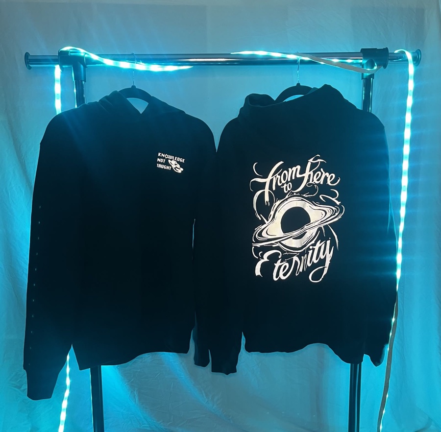 From Here To Eternity — a hoodie set on a rack, Saturn and black hole lettering on the back, small logo on the front